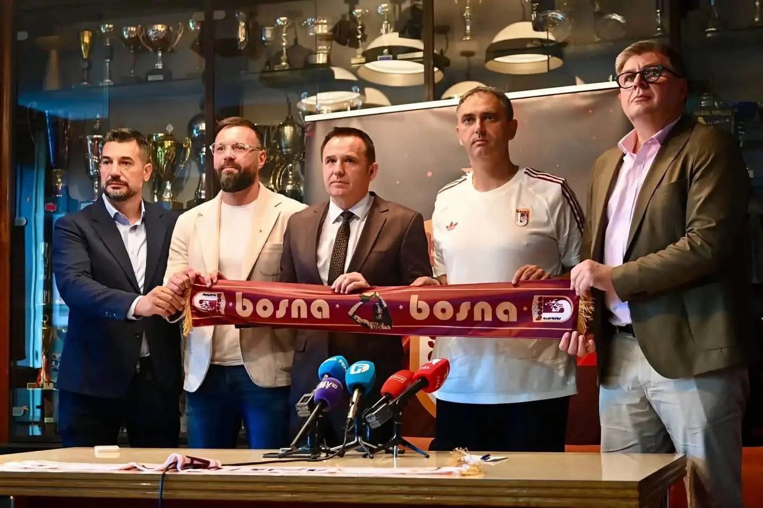Na slici je konferencija za novinare na kojoj je zvanično predstavljeno novo rukovodstvo i trenerski kadar sarajevskog košarkaškog kluba KK Bosna. Na slici su: Damir Kreso – Član Izvršnog odbora kluba i novoimenovani potpredsjednik. Kenan Magoda – Ministar kulture i sporta Kantona Sarajevo. Nihad Selimović – Novoizabrani predsjednik Izvršnog odbora kluba. Dario Gjergja – Istaknuti hrvatsko-belgijski košarkaški menadžer i trenutni glavni trener KK Bosna (kao i košarkaške reprezentacije Bosne i Hercegovine). Amel Kovačević – Potpredsjednik Izvršnog odbora KK Bosna.